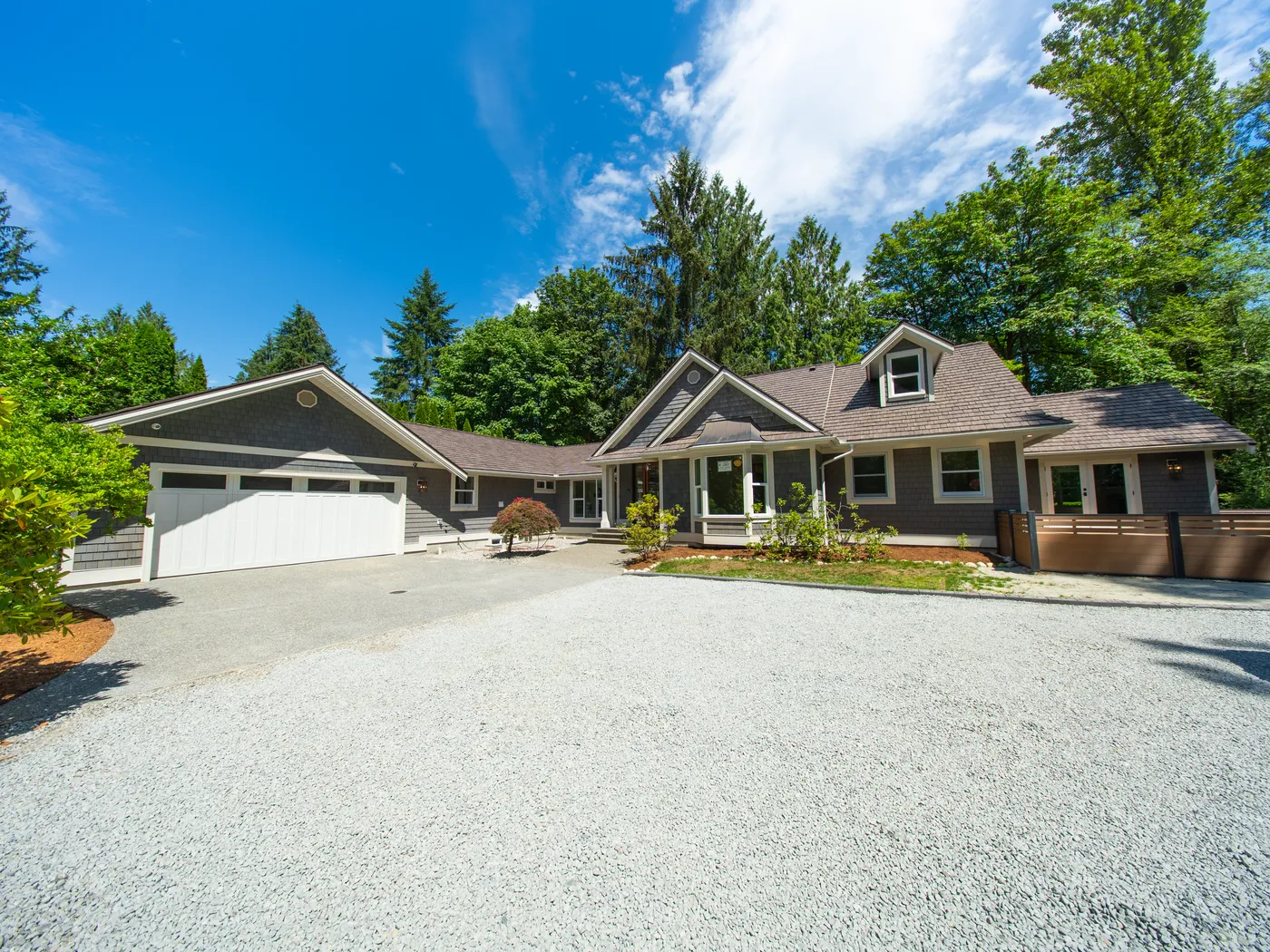 Front exterior with gravel drive and double garage