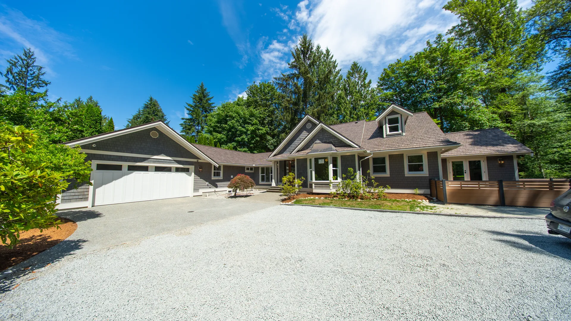 Front exterior with gravel drive and double garage