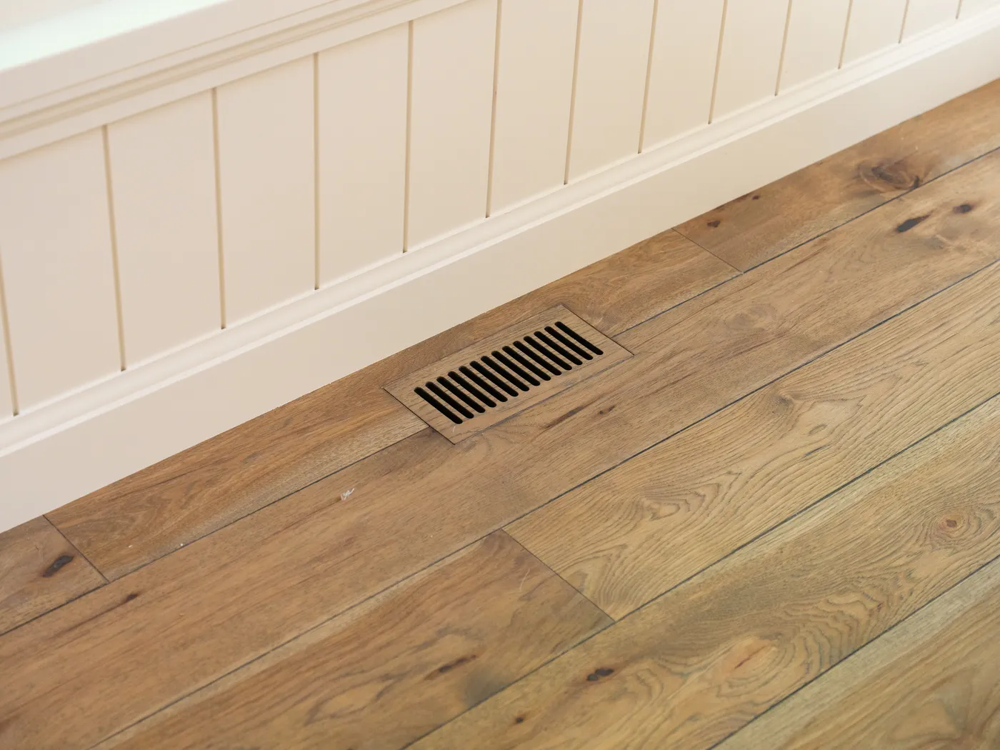 Wide-plank oak flooring against shiplap wall panelling
