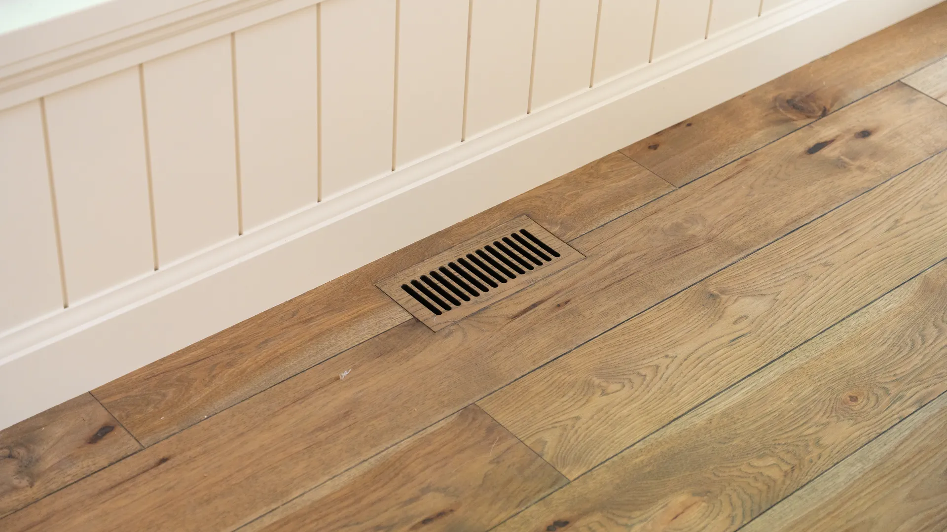 Wide-plank oak flooring against shiplap wall panelling