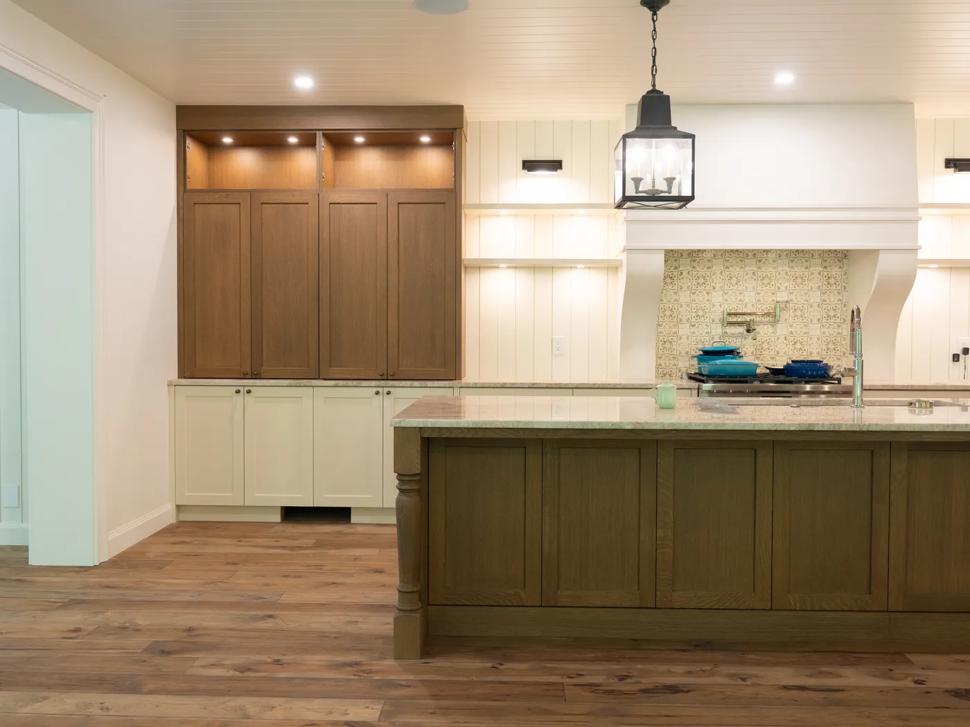 Kitchen with oak island, cream cabinetry, and pendant lighting