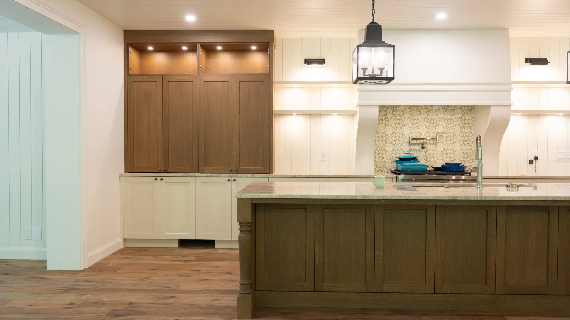 Kitchen with oak island, cream cabinetry, and pendant lighting