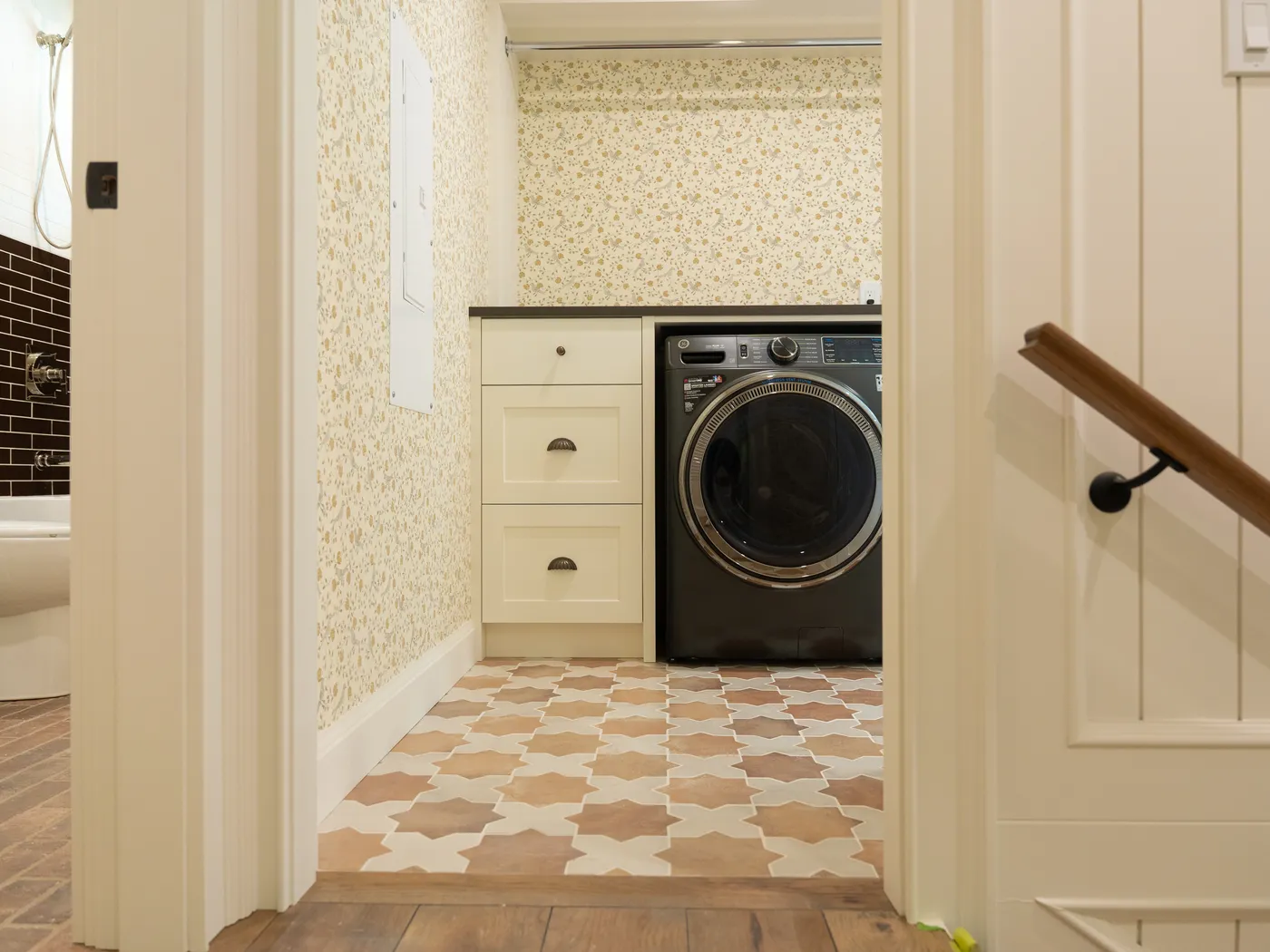 Laundry room with patterned tile floor and custom cabinetry