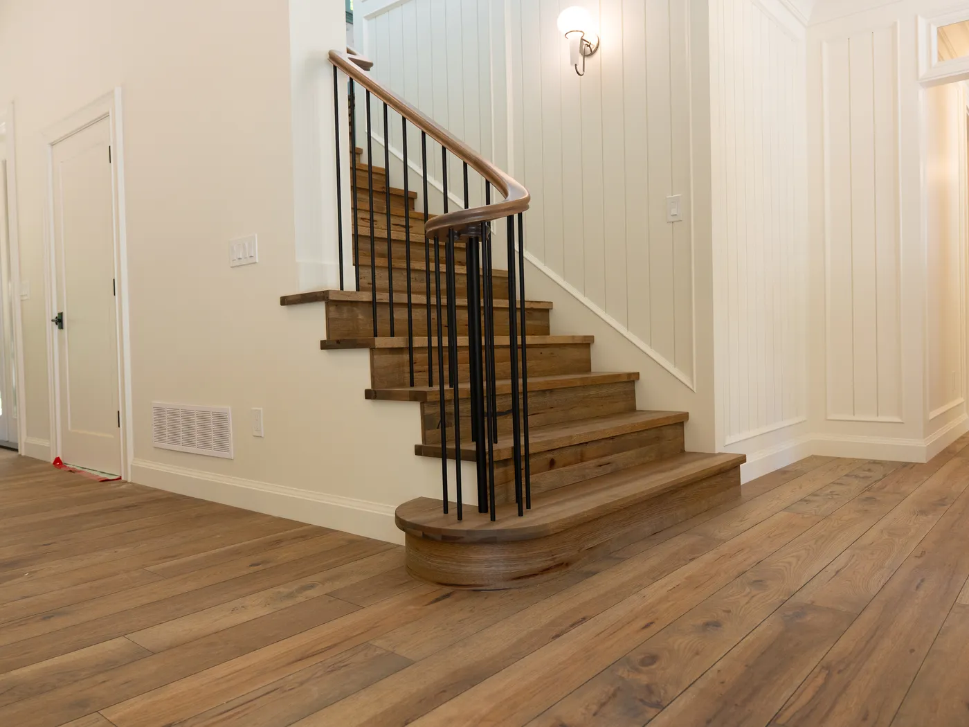 Oak staircase with black metal spindles and shiplap walls