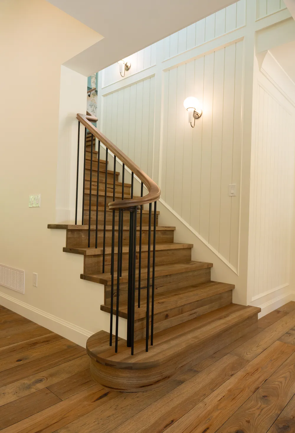 Curved oak staircase with black metal spindles