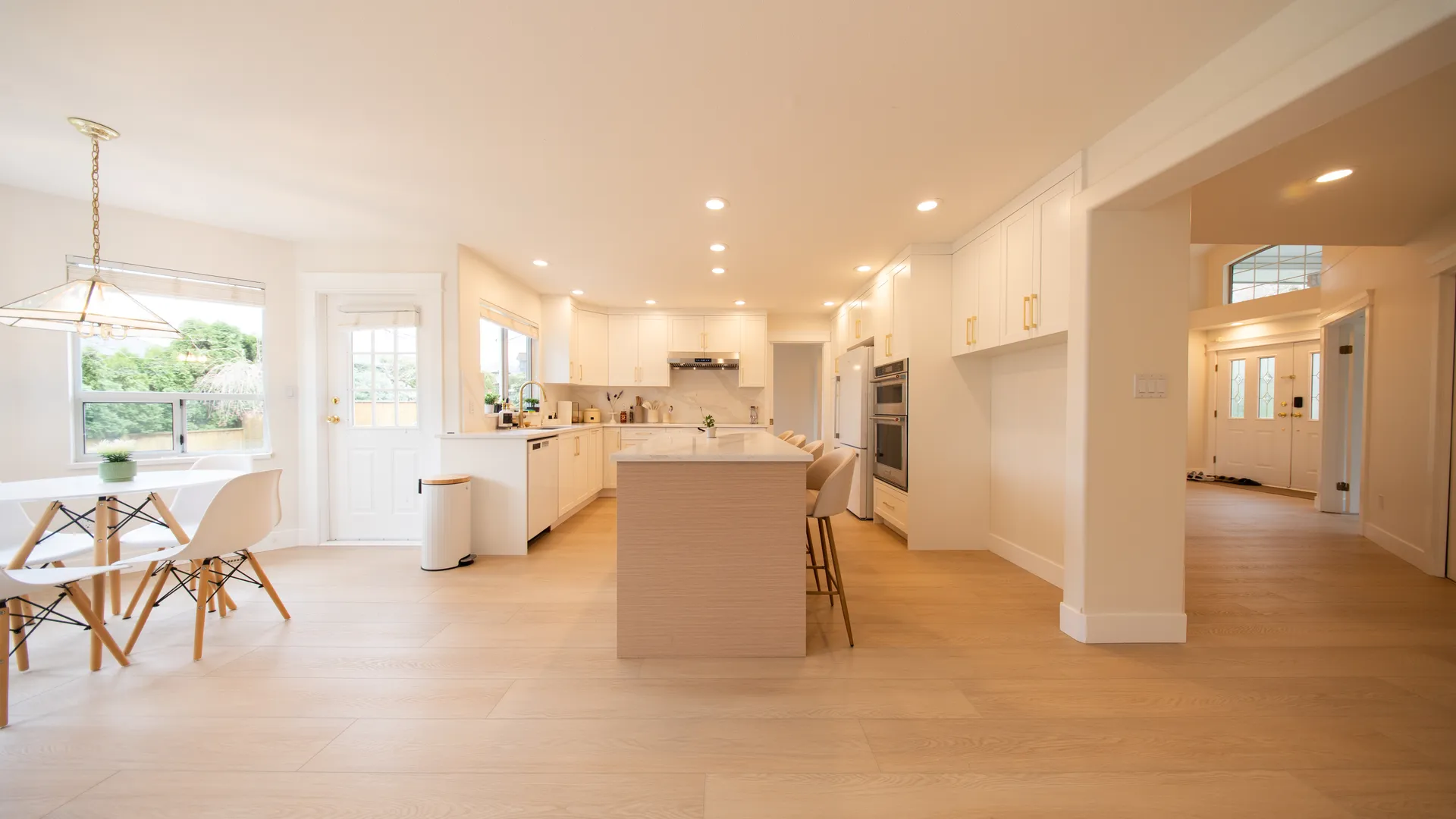 White kitchen with island opening to the dining area