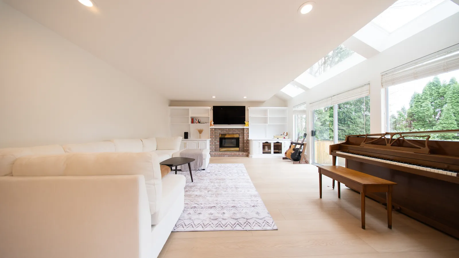 Open-plan living room with skylights and light oak flooring
