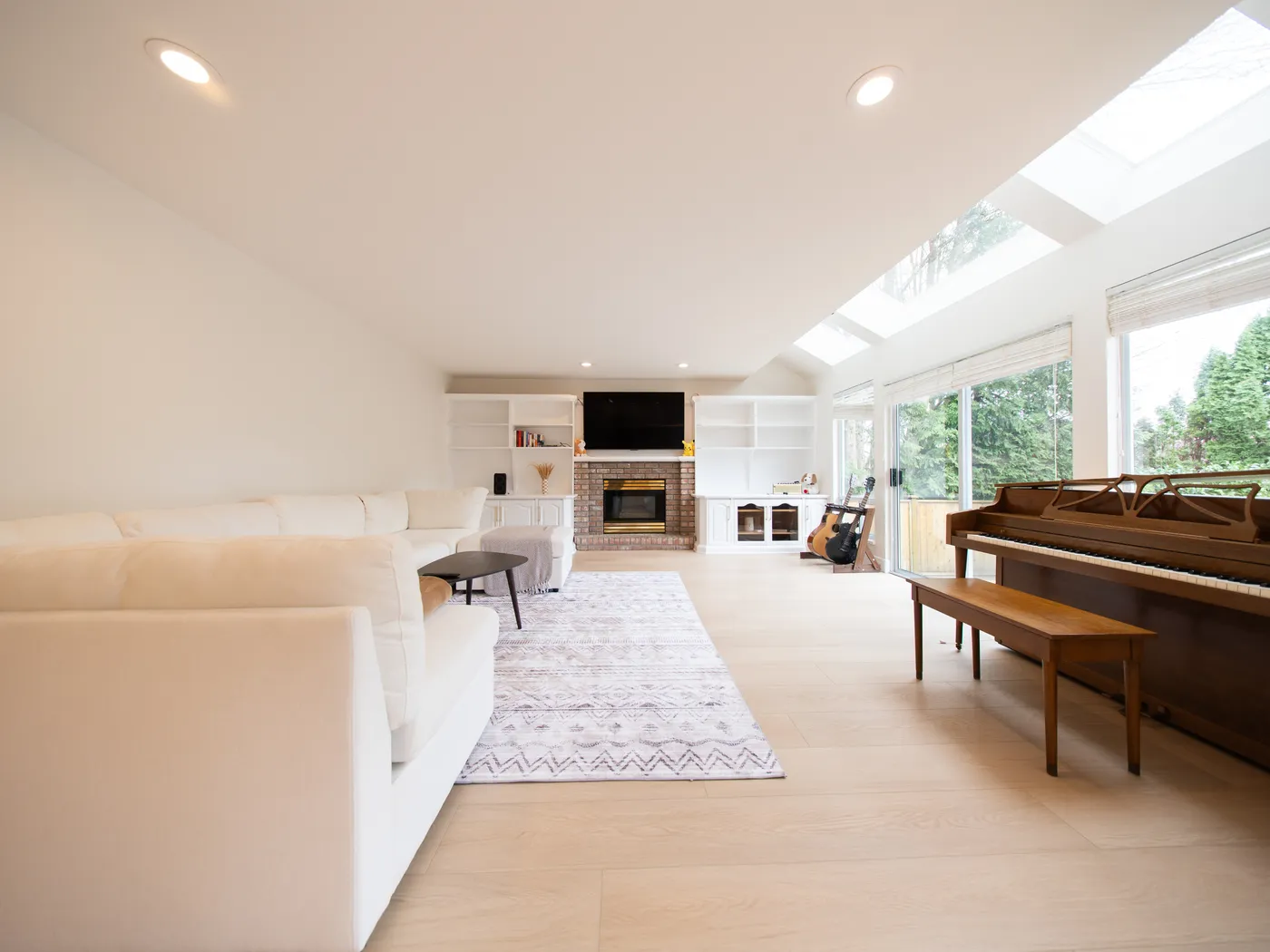 Open-plan living room with skylights and light oak flooring